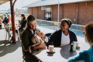 two people with dog at cafe