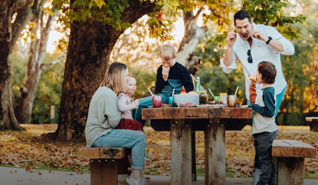 Family enjoying a BBQ picnic at the park