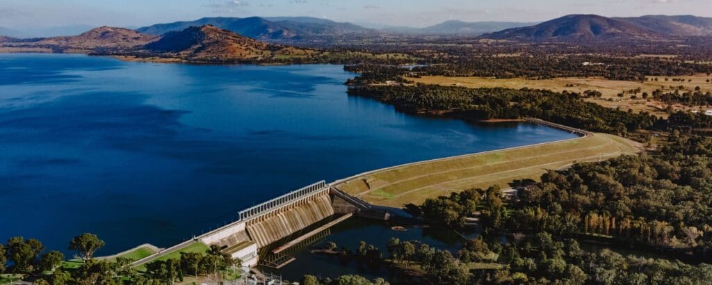 Aerial view of the Hume Dam Wall and the blue waters of Lake Hume and surrounding hills