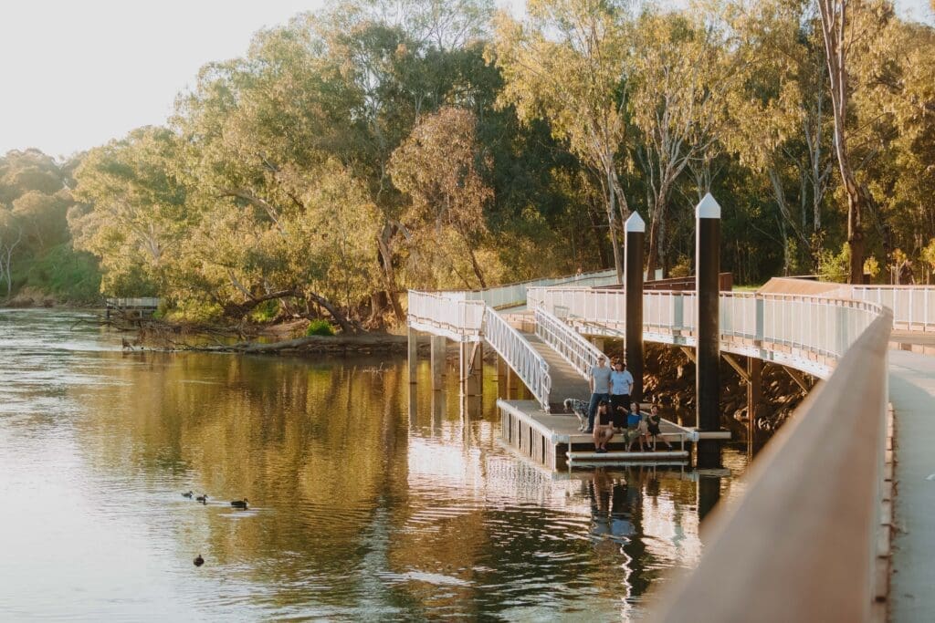 A family stand on a floating pontoon on the banks of the Murray River