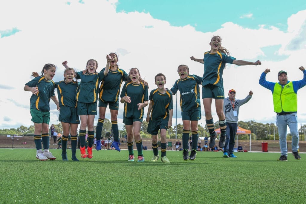 young female football players jumping with excitement